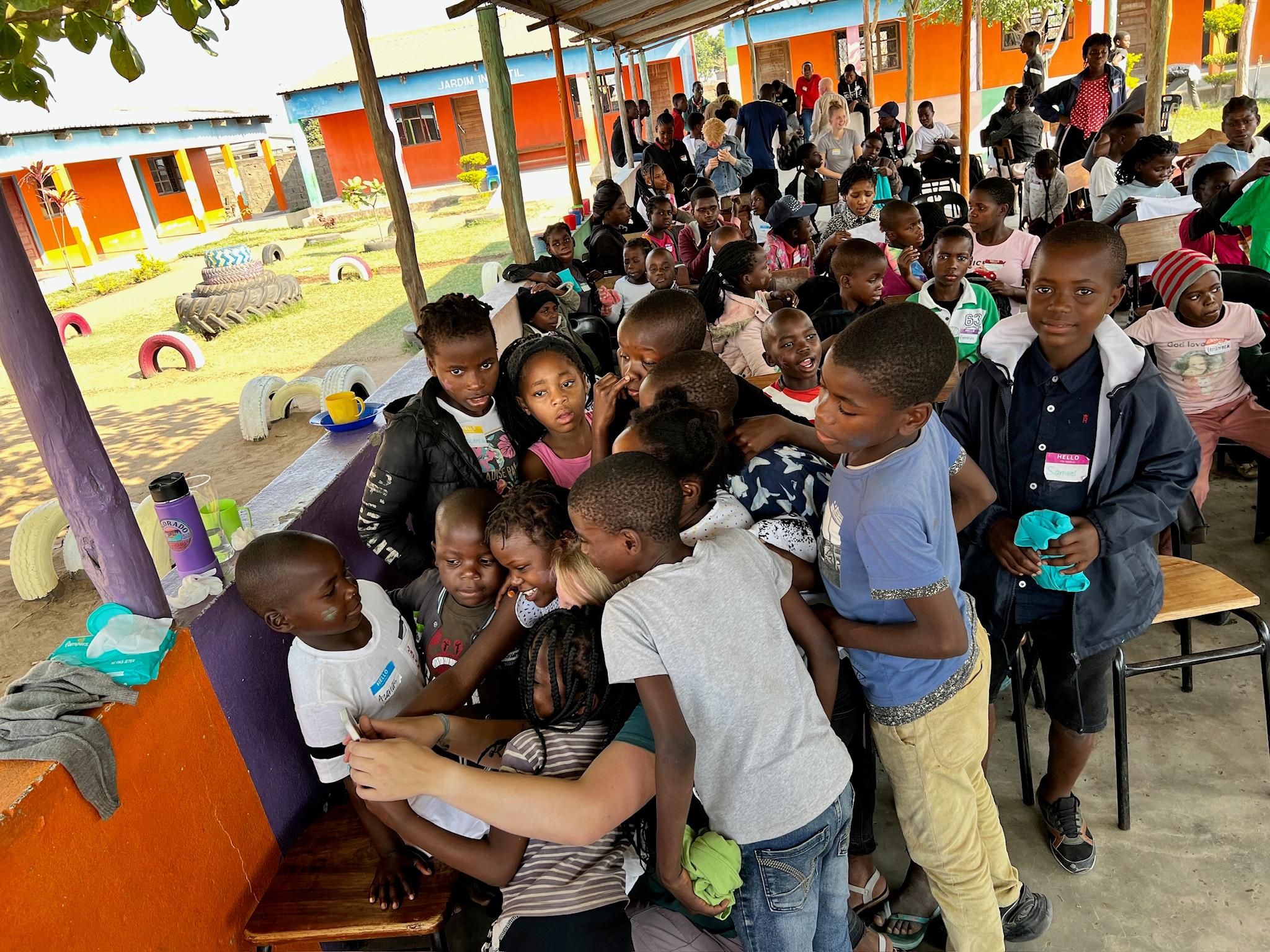 Children gathering around a team member